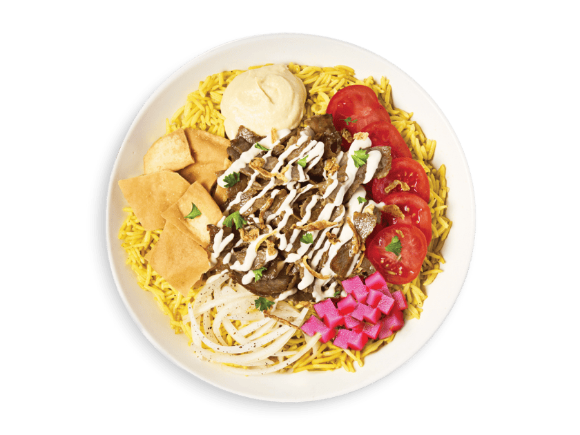Beef shawarma served over rice with onions, pita chips, turnips, hummus, tahini, parsley and tomatoes
